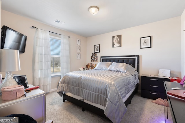 bedroom with baseboards, visible vents, and light carpet