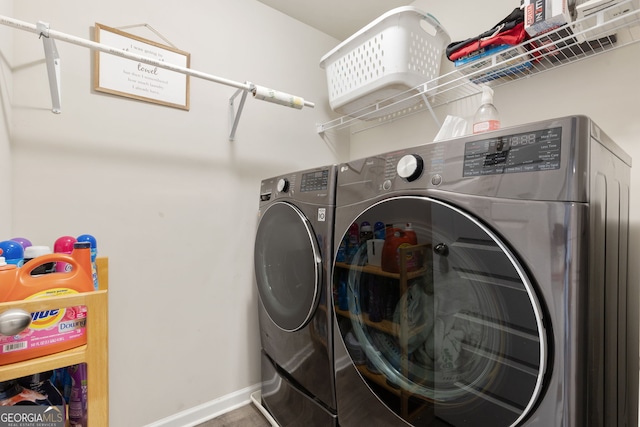 clothes washing area featuring washer and dryer, laundry area, and baseboards