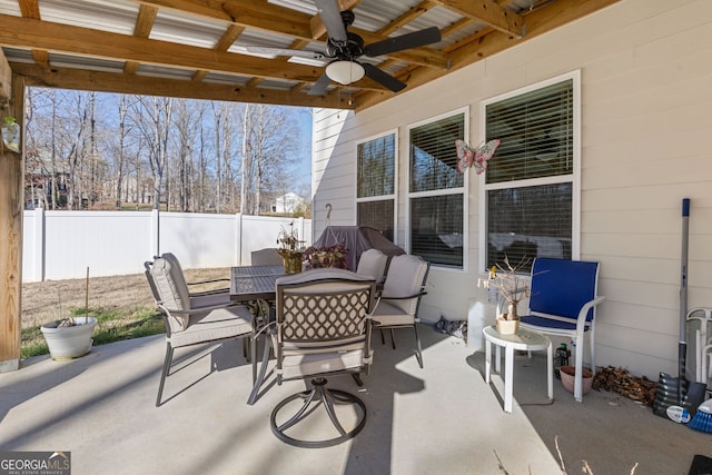 view of patio featuring outdoor dining space, ceiling fan, and fence