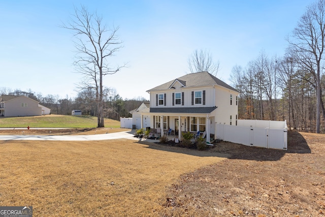 view of front of home with a porch, a shingled roof, a front lawn, and fence