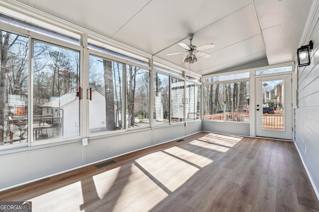 unfurnished sunroom with a ceiling fan, visible vents, vaulted ceiling, and a wealth of natural light