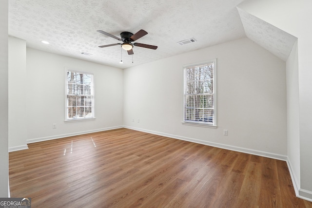 interior space featuring visible vents, a textured ceiling, and wood finished floors