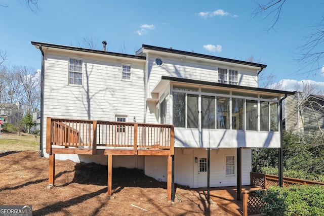 rear view of property with a sunroom and a deck