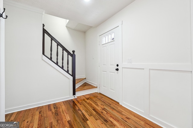 foyer entrance with stairway and wood finished floors