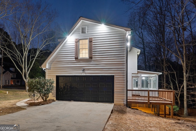 view of front of home featuring a garage, a deck, and concrete driveway