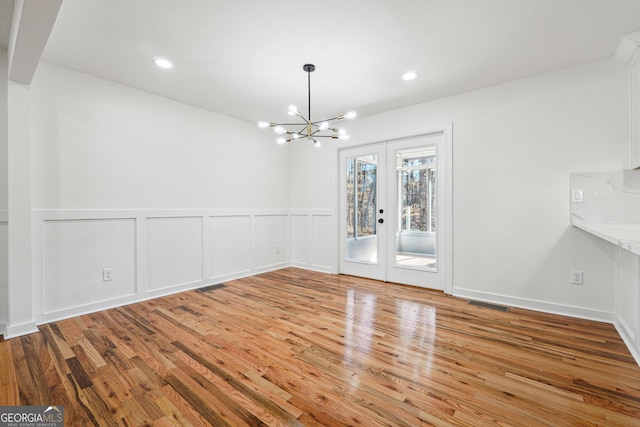 unfurnished dining area featuring recessed lighting, french doors, visible vents, and wood finished floors