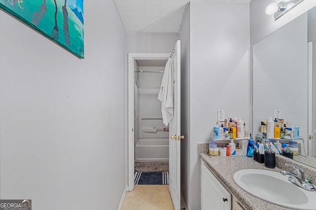 bathroom featuring vanity, a textured ceiling, and bathing tub / shower combination