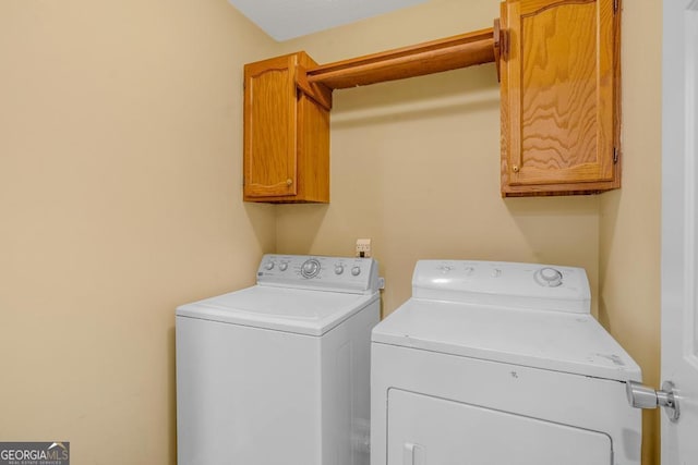 clothes washing area featuring cabinet space and washer and dryer