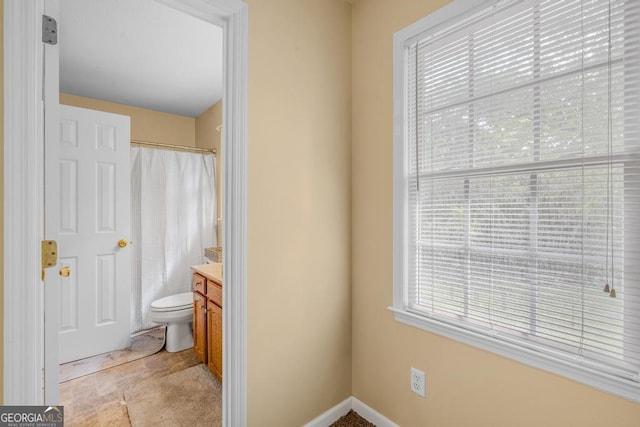 bathroom featuring toilet, baseboards, vanity, and a shower with curtain