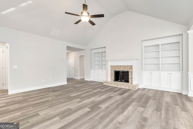 unfurnished living room featuring a brick fireplace, ceiling fan, light wood-style flooring, and baseboards