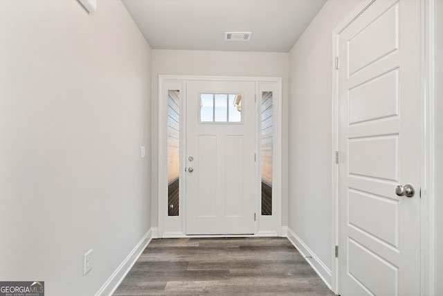 foyer entrance with dark wood-style flooring, visible vents, and baseboards