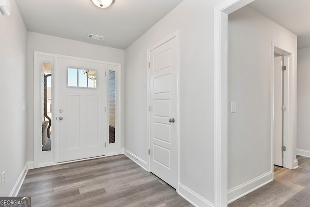 entryway featuring visible vents, baseboards, and wood finished floors