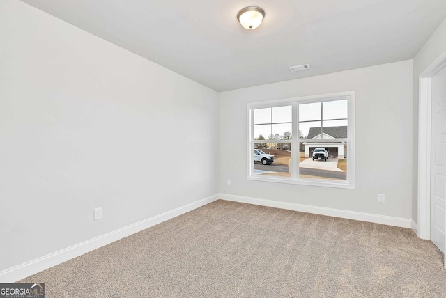 carpeted empty room with visible vents and baseboards