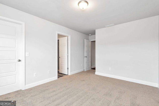 unfurnished bedroom with carpet floors and baseboards