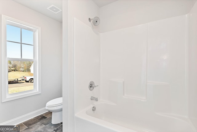 bathroom featuring toilet, shower / bathtub combination, visible vents, and baseboards