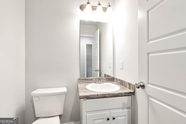 half bathroom with vanity and toilet