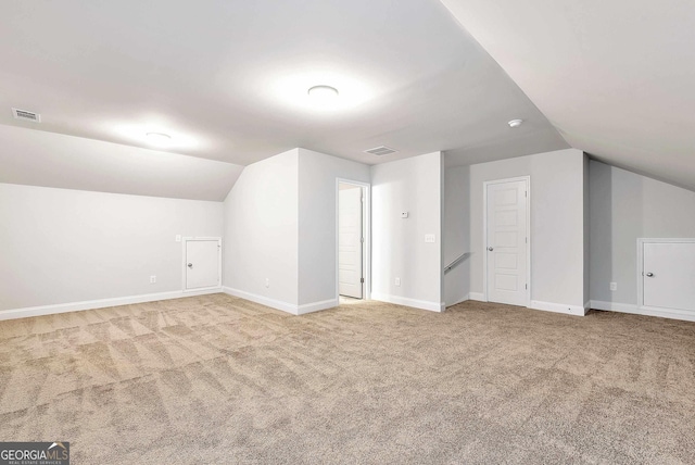 bonus room featuring carpet, visible vents, and vaulted ceiling