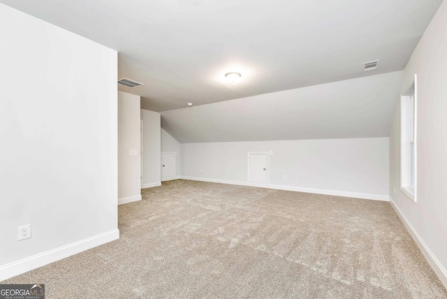 additional living space featuring baseboards, visible vents, and carpet flooring