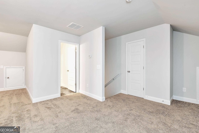 bonus room with carpet floors, lofted ceiling, visible vents, and baseboards