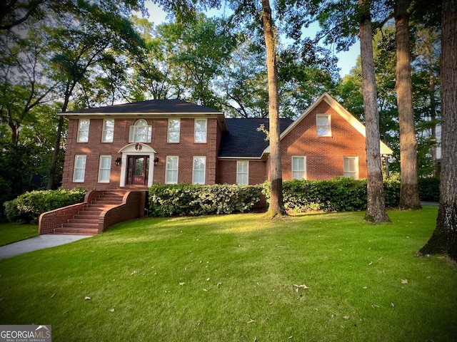 view of front of home featuring a front yard and brick siding