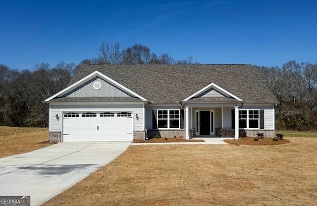 craftsman-style home with a front lawn, brick siding, driveway, and an attached garage