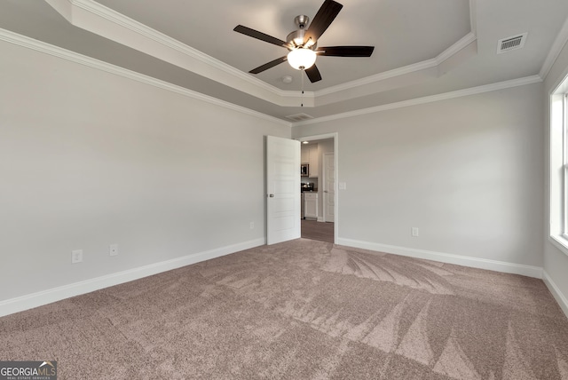 unfurnished room with baseboards, visible vents, a tray ceiling, and carpet flooring