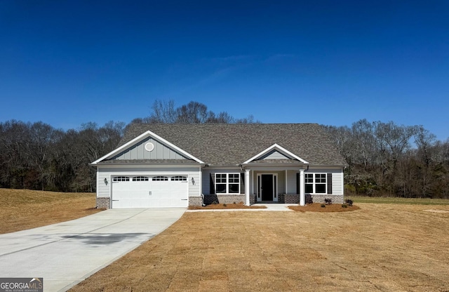 view of front facade with a garage, brick siding, driveway, a front lawn, and board and batten siding