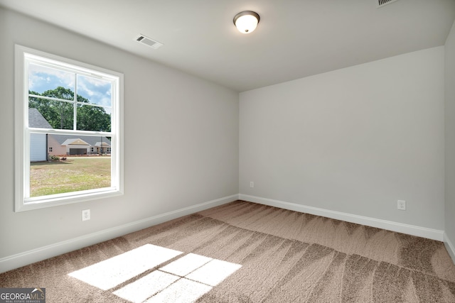 carpeted spare room with baseboards and visible vents