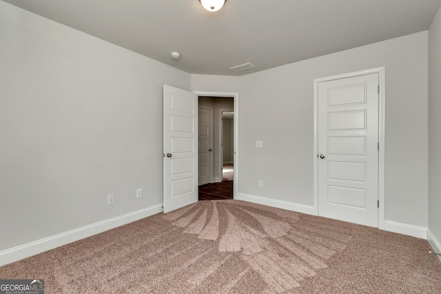 unfurnished bedroom featuring carpet floors, visible vents, and baseboards