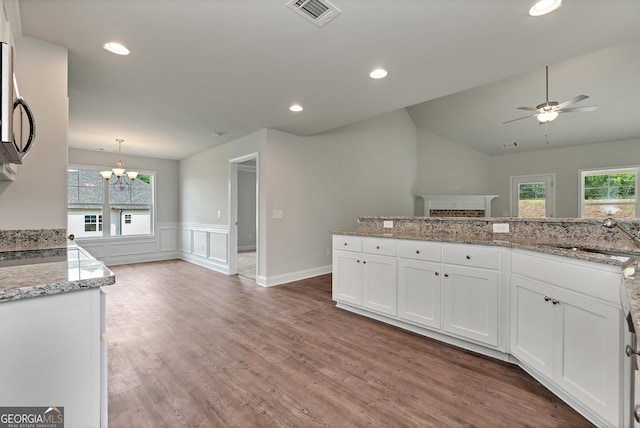 kitchen with plenty of natural light, white cabinetry, visible vents, and a sink