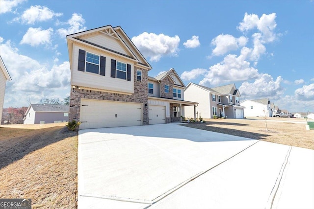 view of front of property with an attached garage, driveway, a residential view, and brick siding