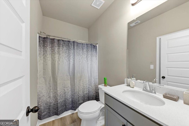 full bathroom with curtained shower, visible vents, toilet, vanity, and wood finished floors