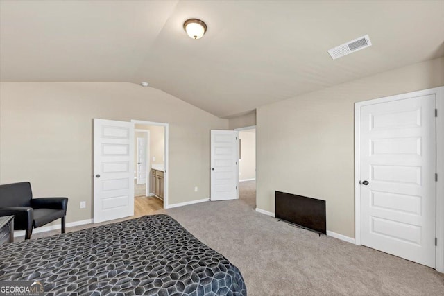 bedroom featuring light carpet, baseboards, visible vents, and vaulted ceiling