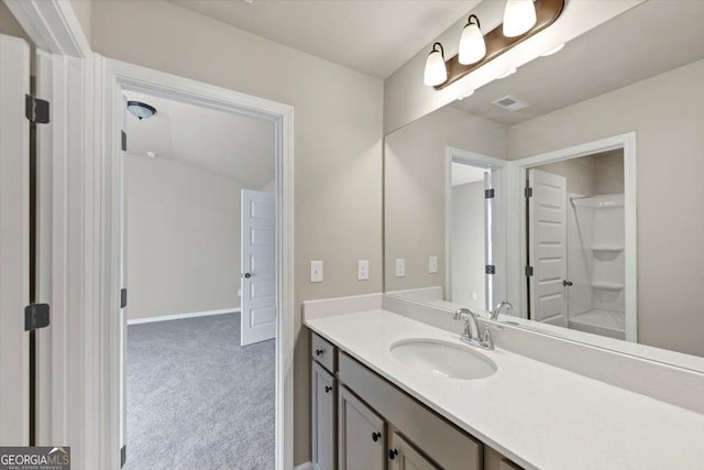 full bathroom with visible vents, vanity, baseboards, and walk in shower