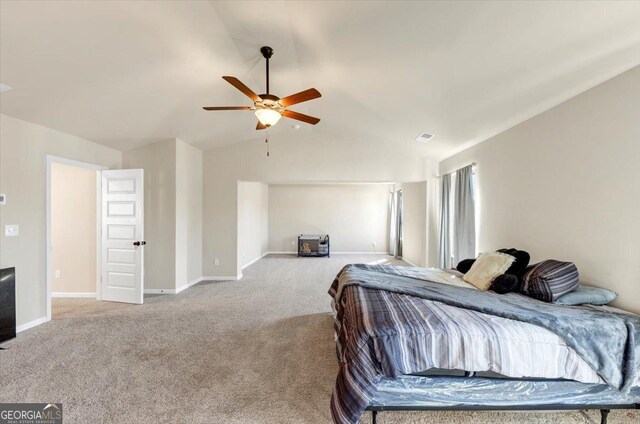 carpeted bedroom featuring lofted ceiling, baseboards, visible vents, and ceiling fan