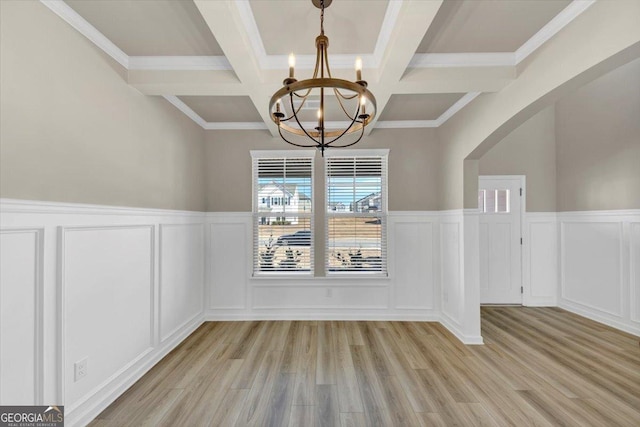 unfurnished dining area featuring an inviting chandelier, beam ceiling, and a decorative wall