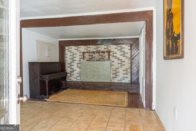 unfurnished living room with a fireplace, ornamental molding, and tile patterned floors
