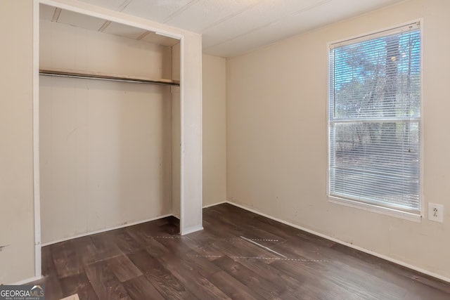 unfurnished bedroom featuring dark wood-type flooring and a closet