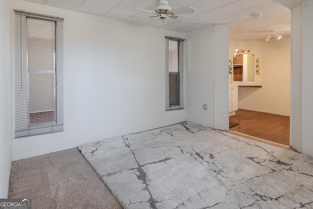 carpeted empty room with a ceiling fan