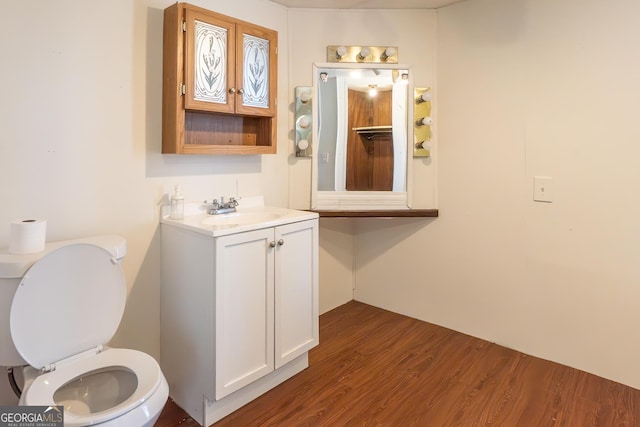 bathroom featuring wood finished floors, toilet, and vanity