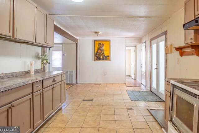 kitchen with under cabinet range hood, visible vents, electric stove, and light tile patterned flooring