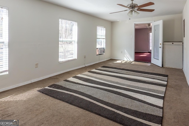carpeted empty room featuring a ceiling fan and baseboards