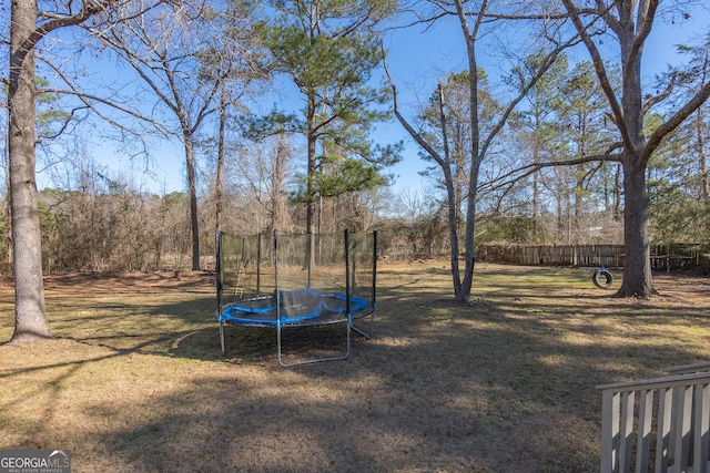 view of yard with fence and a trampoline