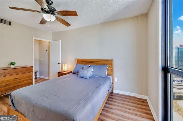 bedroom featuring multiple windows, wood finished floors, and visible vents