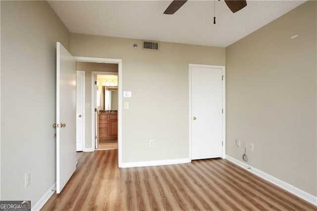 unfurnished bedroom featuring light wood-style floors, visible vents, baseboards, and a ceiling fan