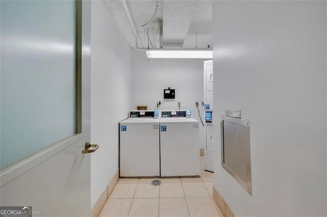 interior space with washer and dryer, stacked washer / dryer, a textured ceiling, and tile patterned floors