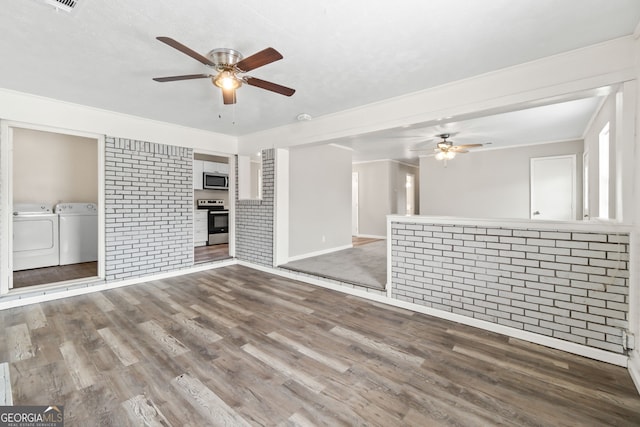 unfurnished living room featuring brick wall, ceiling fan, wood finished floors, and independent washer and dryer