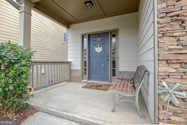 property entrance featuring covered porch and stone siding