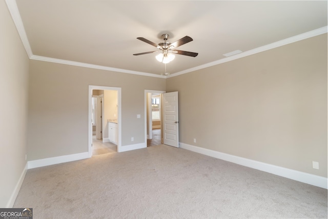 unfurnished bedroom with crown molding, baseboards, and light colored carpet