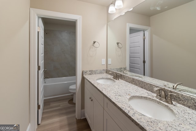 bathroom featuring a sink, toilet, and wood finished floors